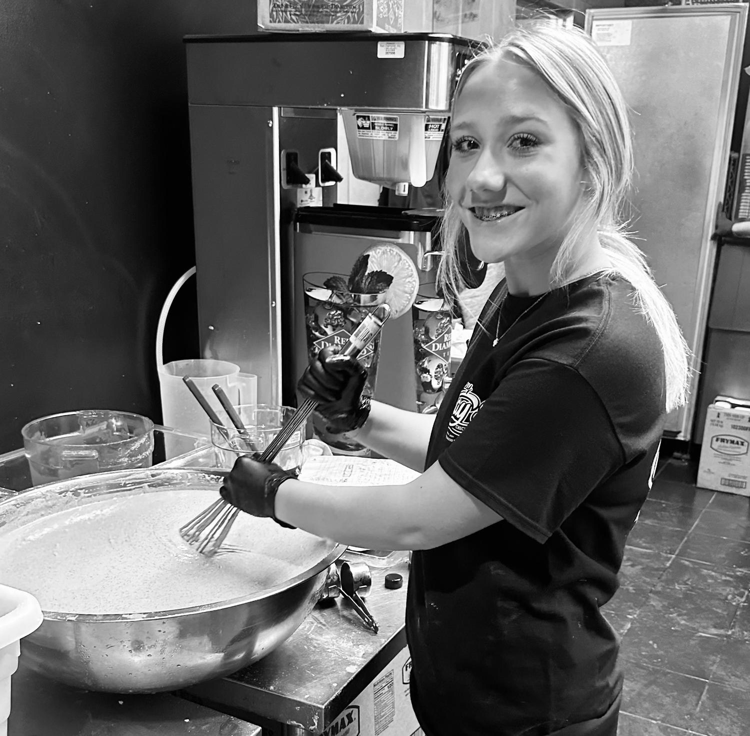 A Ray Ray's team member mixing batter in the kitchen